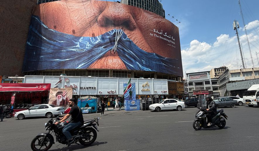 Vehicles drive past a billboard with graphic showing Strait of Hormuz and sewn lips of U.S. President Donald Trump in a square in downtown Tehran, Iran, Saturday, May 2, 2026. (AP Photo/Vahid Salemi)