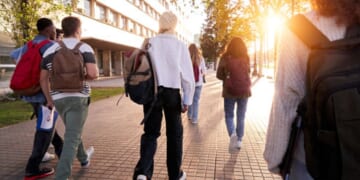 Students walk on a college campus.