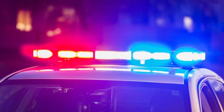 The roof of a police patrol car at night, with the blue and red lights flashing.