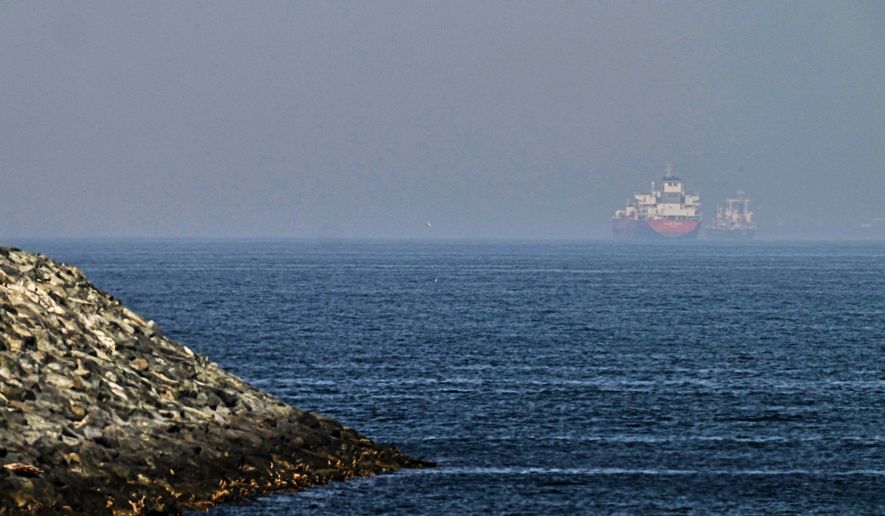 Cargo ships are seen at sea near the Strait of Hormuz, as viewed from a rocky shoreline near Khor Fakkan, United Arab Emirates, Friday, May 1, 2026. (AP Photo/Fatima Shbair)