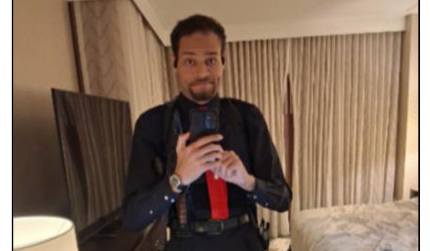 This image contained in a court filing by the Department of Justice, April 29, 2026, shows Cole Tomas Allen, left, inside his hotel room, on Saturday, April 25, 2026 in Washington, using his cellphone to take a photograph of himself in the mirror. (Department of Justice via AP)