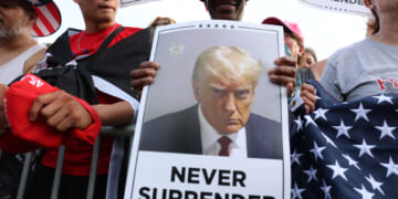 A Trump supporter holds a photo of Donald Trump never surrender. (Spencer Platt/Getty Images)