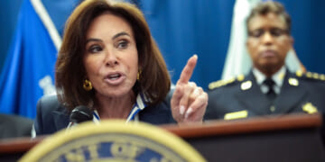 Close-up of Jeanine Pirro speaking at podium and pointing with her left hand.