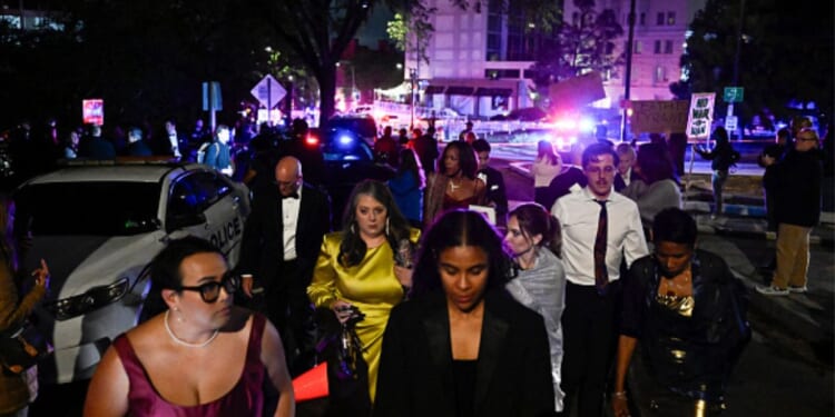 Outside the Washington Hilton on April 25, 2026 a crowd stands gathered after the shooting incident at the WHCD.
